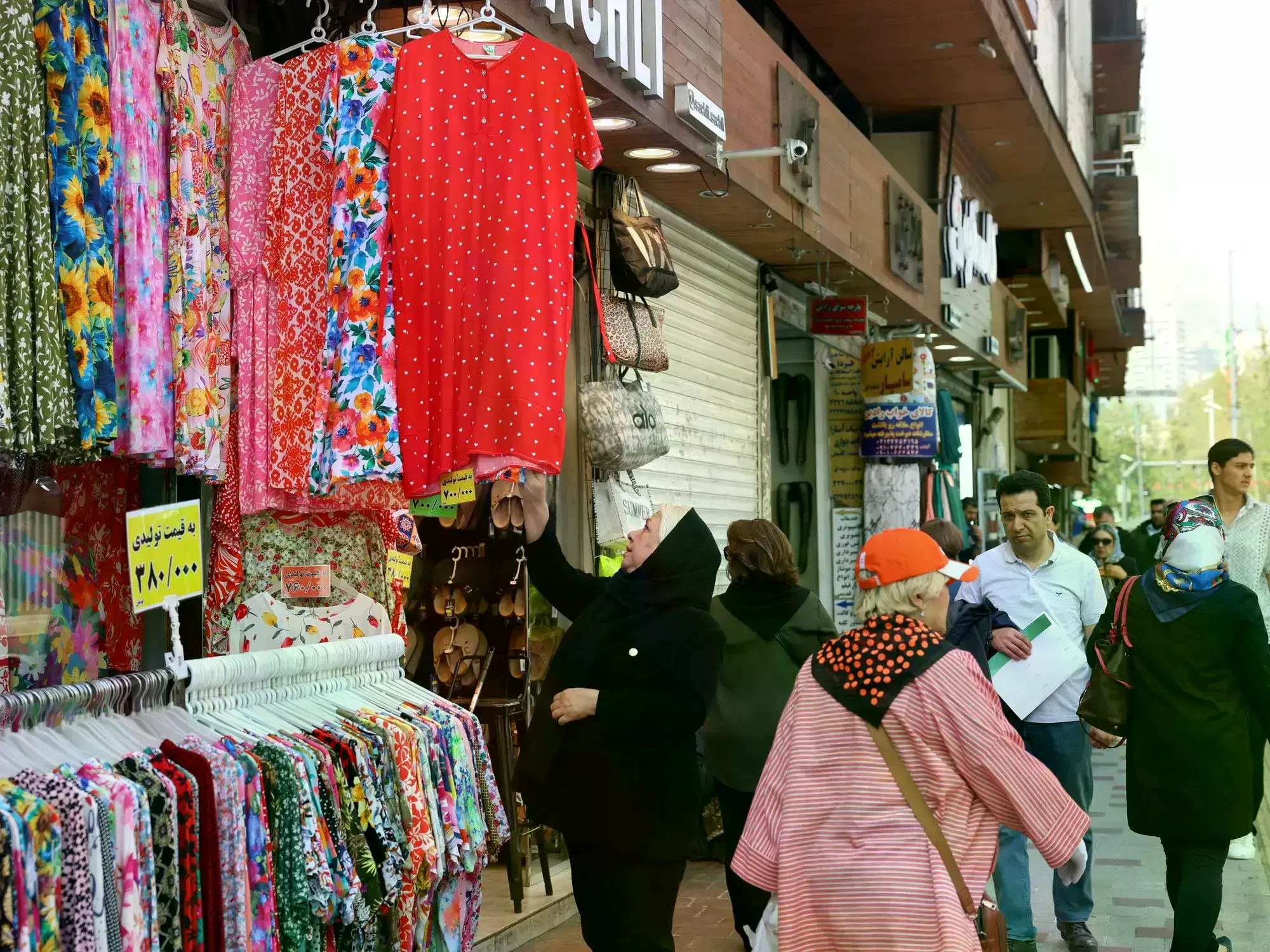 Ciudadanos iraníes pasan junto a grandes retratos de las estudiantes de Minab que murieron en un ataque aéreo en la plaza Taj