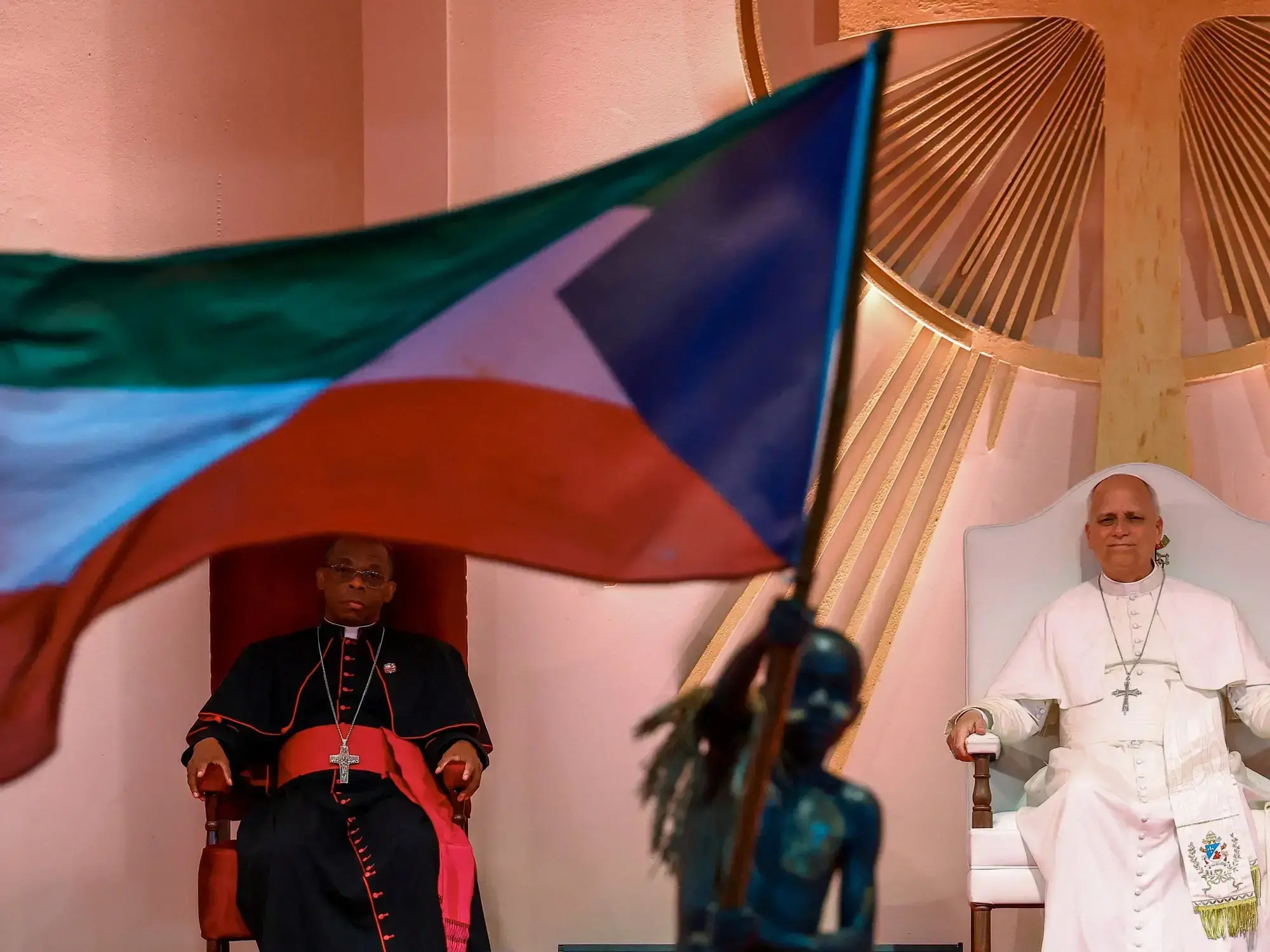 Un niño ondea una bandera de Guinea Ecuatorial mientras el Papa León XIV asiste a un encuentro en el estadio de Bata.