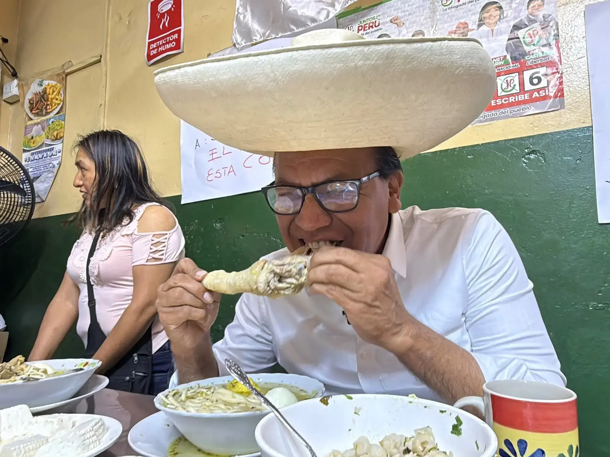 El candidato Roberto Sánchez desayuna en un mercado de Lima durante su campaña.