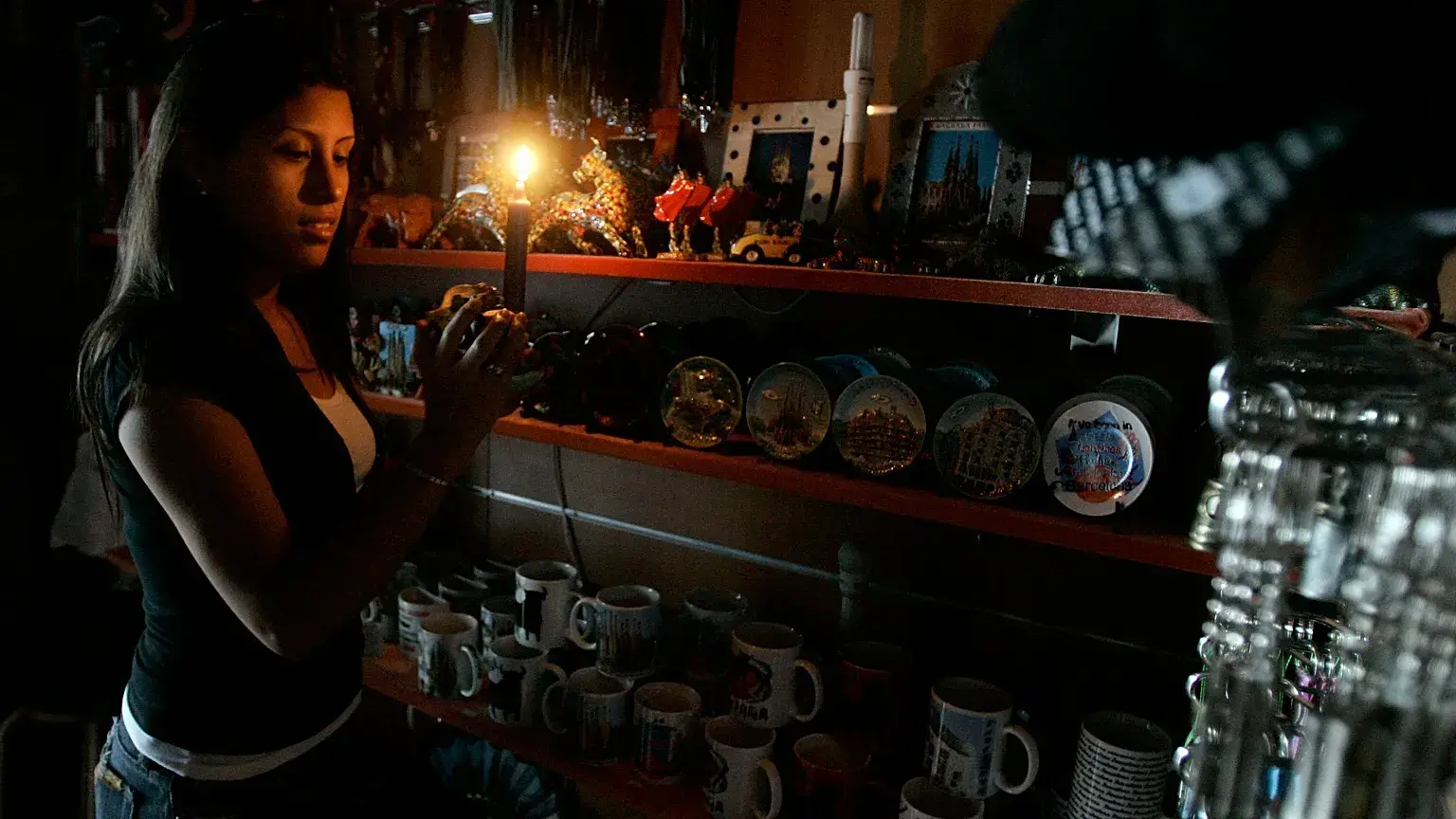 Una mujer trabaja en una tienda a la luz de una vela en Barcelona, España, el 24 de julio de 2007.