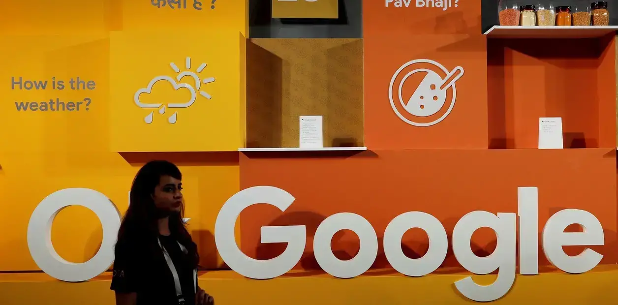 Una mujer pasa junto al logotipo de Google durante un evento en Nueva Delhi, India.
