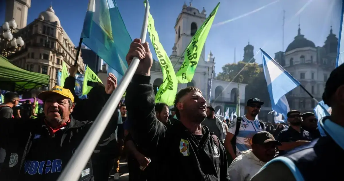 Personas sostienen banderas durante una protesta convocada por la CGT contra el Gobierno de Javier Milei en Buenos Aires.