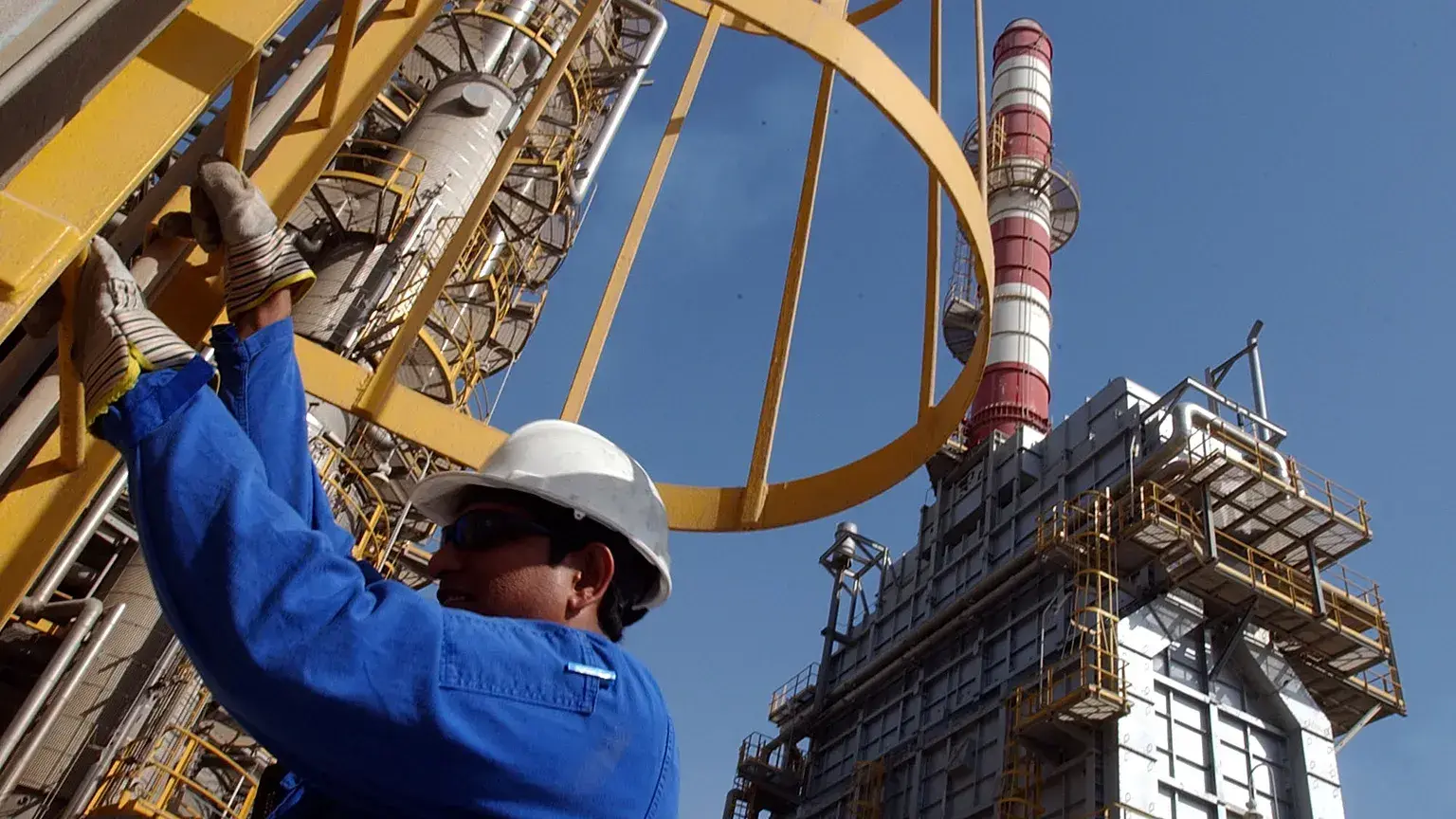 Un técnico petrolero desciende por una torre en una refinería en Jebel Ali, Emiratos Árabes Unidos.