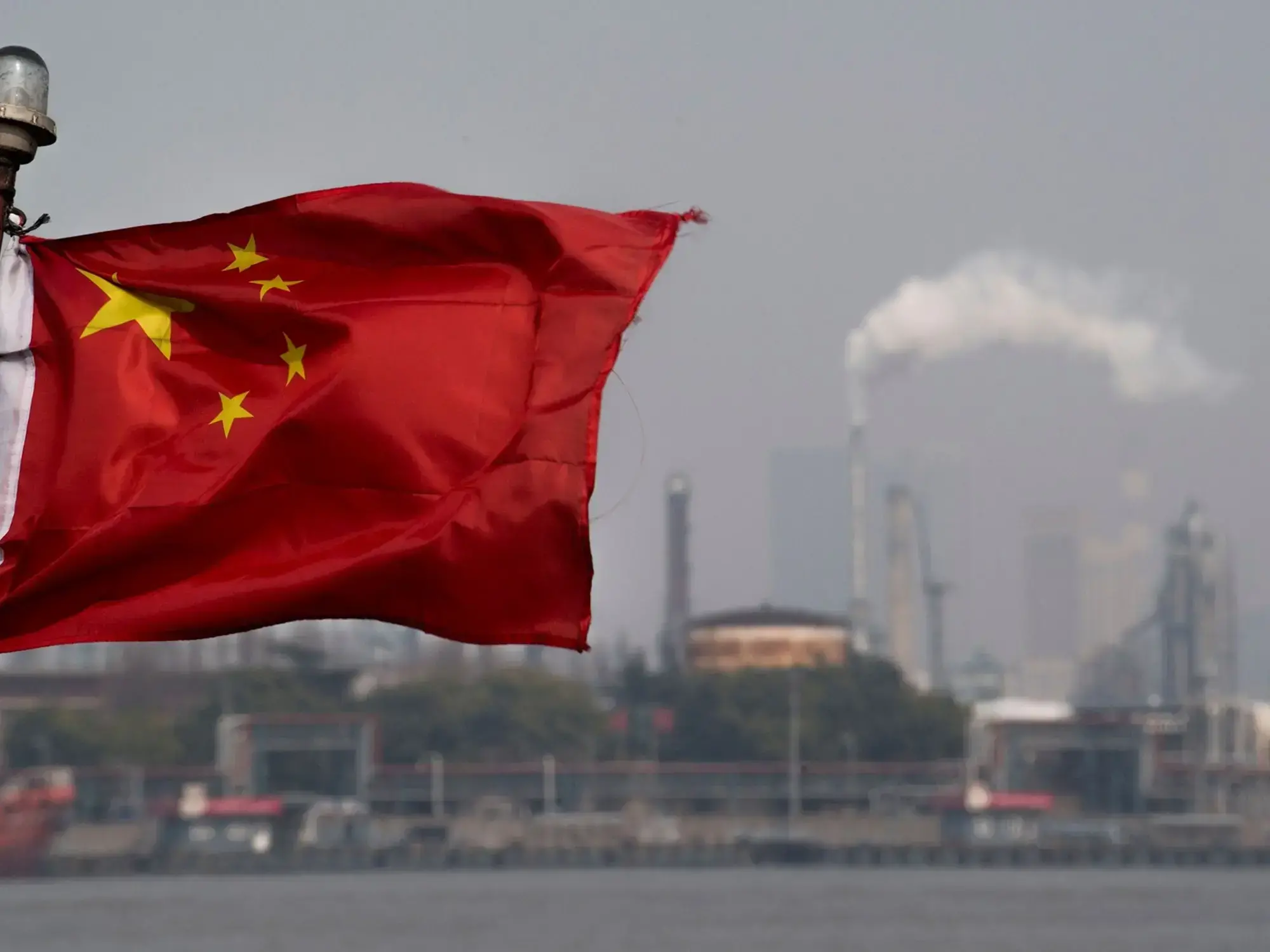 Una bandera china ondea frente a la refinería de Shanghai Gaoqiao en Shanghái.