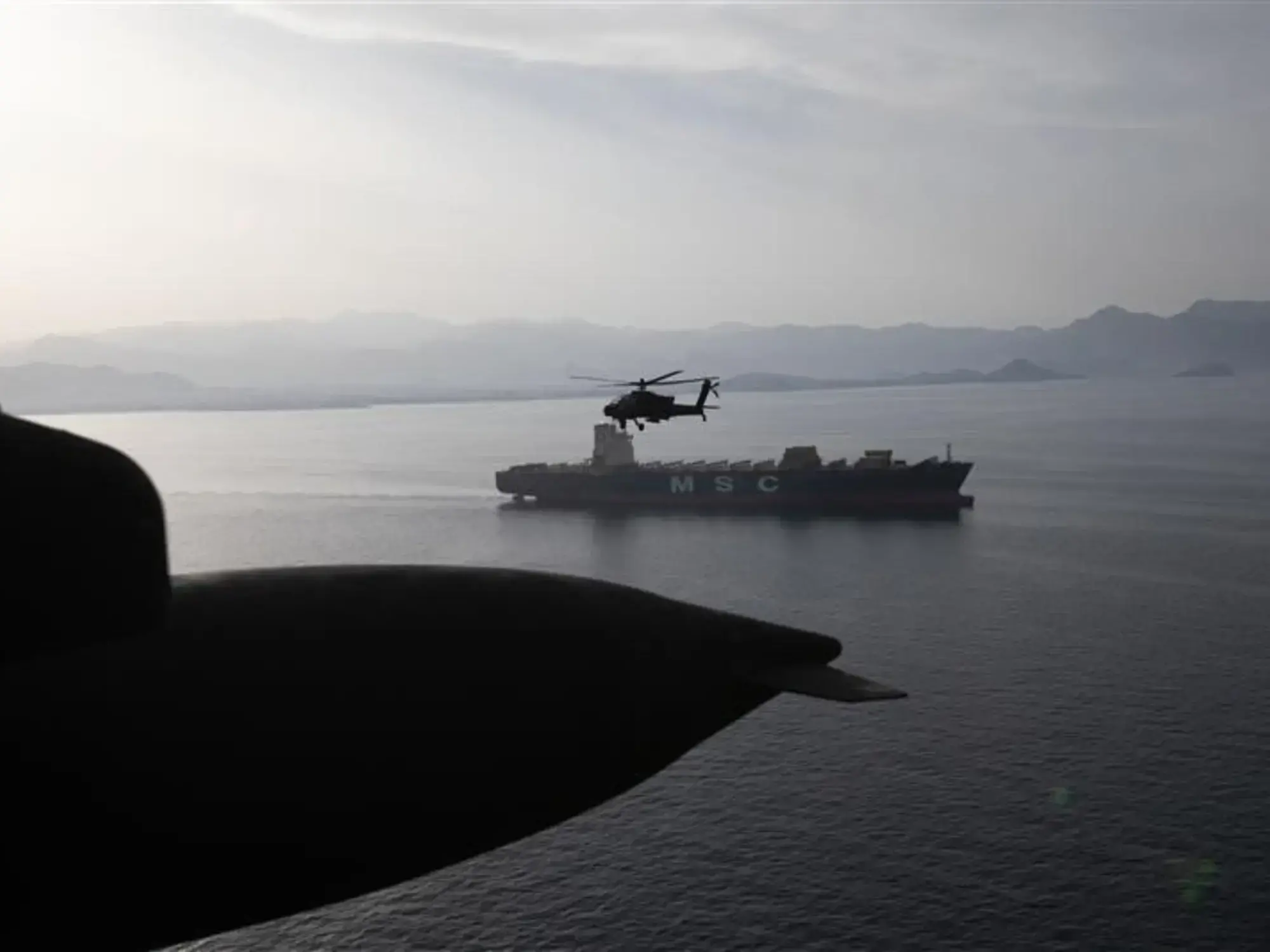 Un helicóptero Apache vuela sobre el Estrecho de Ormuz durante una patrulla.