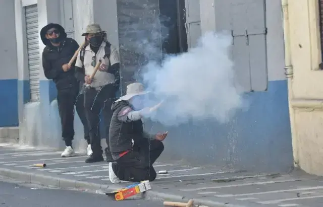 Los marchistas de la COB lanzan petardos a los policías.