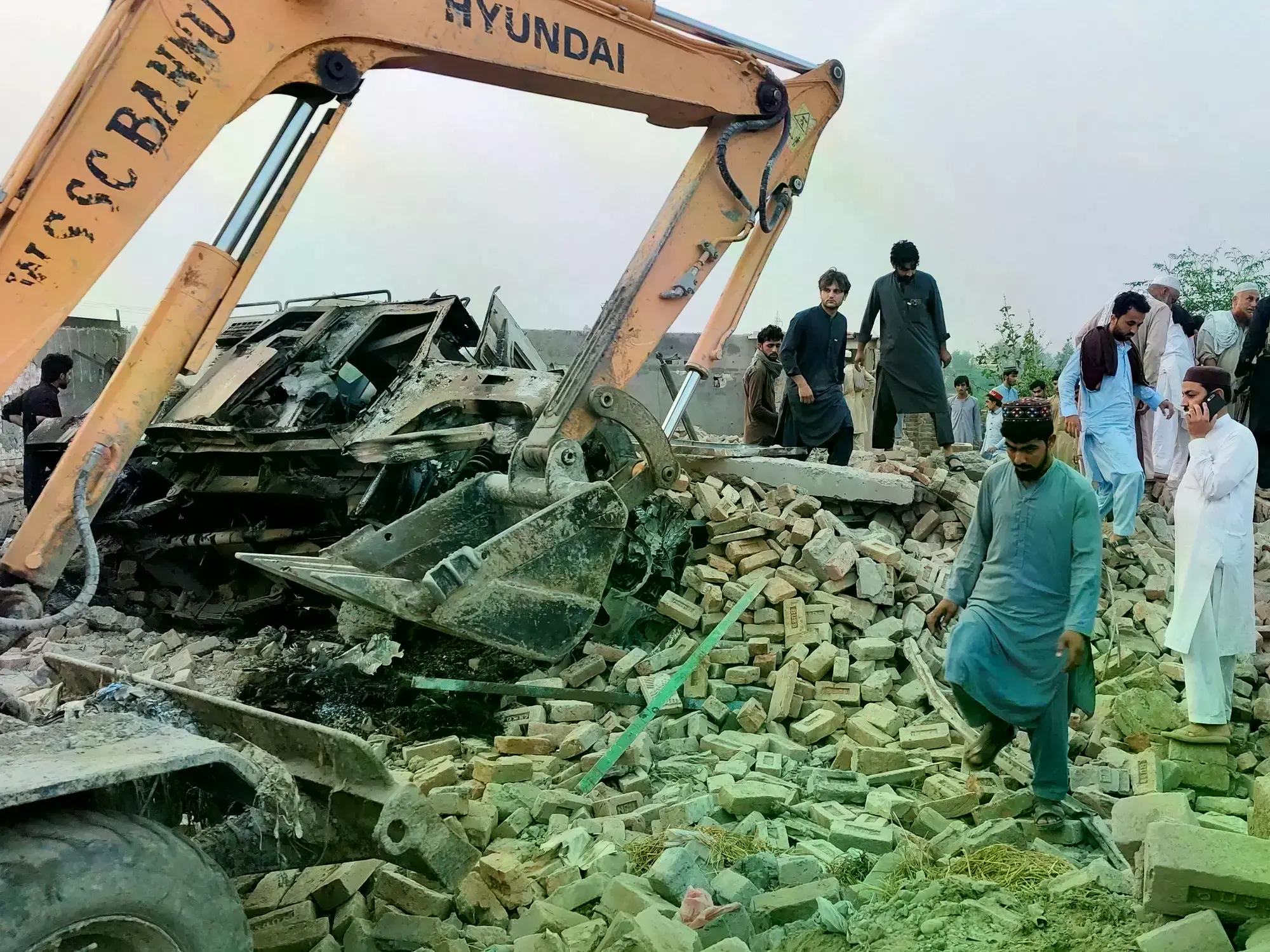 Los socorristas y vecinos remueven los escombros tras el atentado en Pakistán.