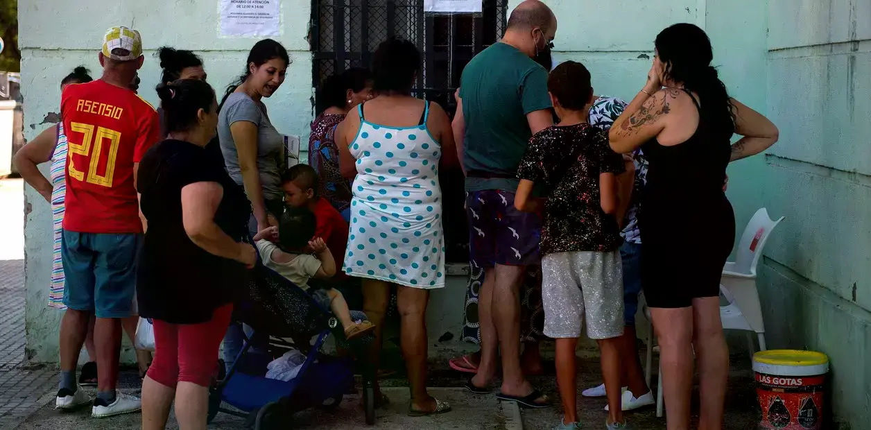 Personas comen después de recibir comida donada por la iglesia griega en el centro de Atenas, Grecia.