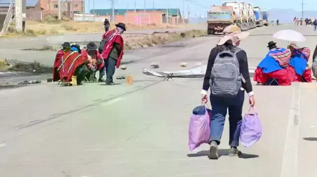 Una ciudadana se traslada a pie en un punto de bloqueo en La Paz, el departamento que concentra casi la totalidad de los cort