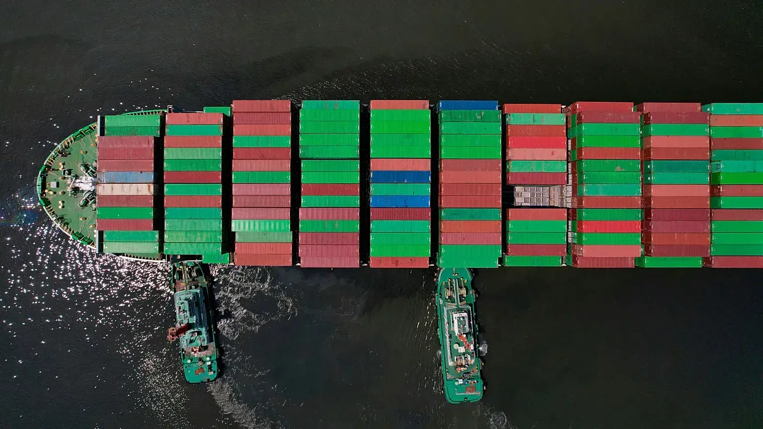 Remolcadores ayudan a un portacontenedores mientras se prepara para atracar en la terminal de contenedores de Manila, Filipin