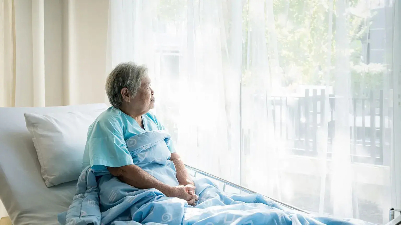 Una mujer permanece en una cama de hospital y mira hacia la luz. Tras una infección por hantavirus, muchos sufren secuelas fí