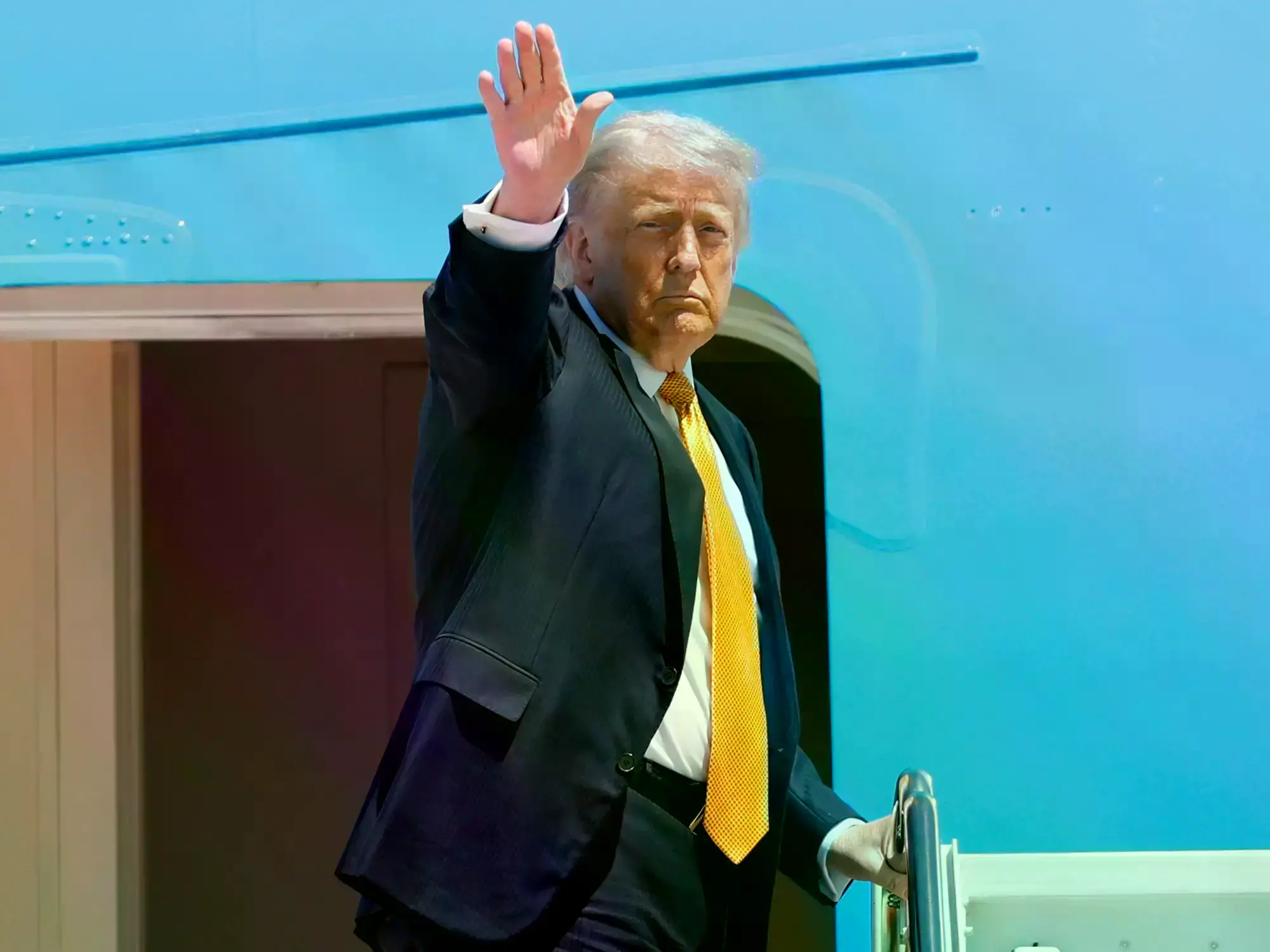 Donald Trump saluda al embarcar el Air Force One con destino China.