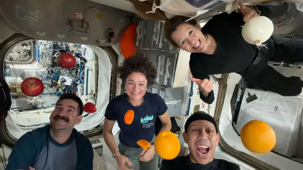 Los astronautas posan con fruta fresca en microgravedad a bordo de la ISS.