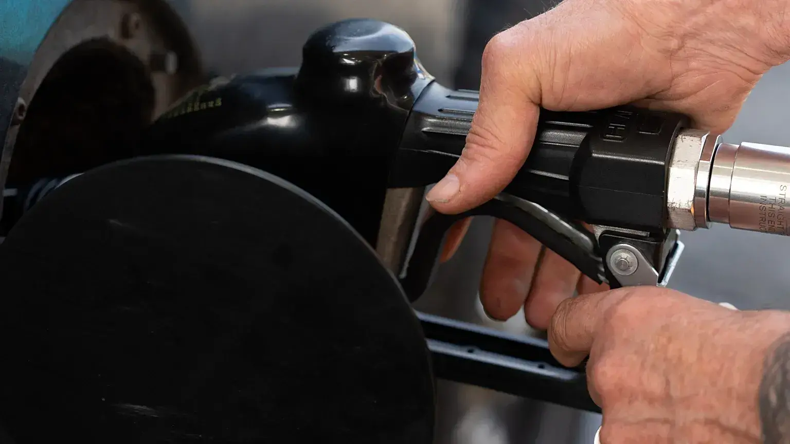 Una persona asegura la boquilla de combustible mientras llena el tanque de su vehículo en una gasolinera el martes 12 de mayo