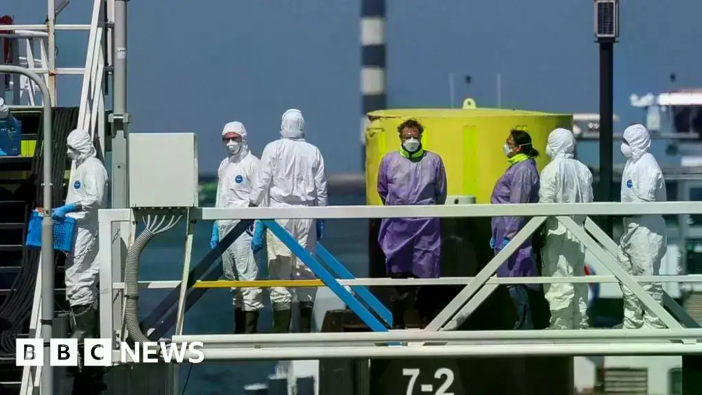 Trabajadores con equipo de protección abordan el MV Hondius en Róterdam.