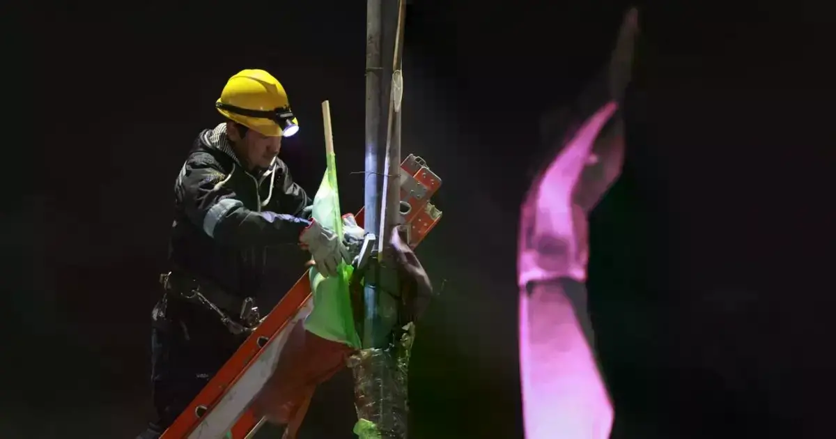 Grupo de funcionarios municipales retirando banderas políticas en la zona del Cristo Redentor.