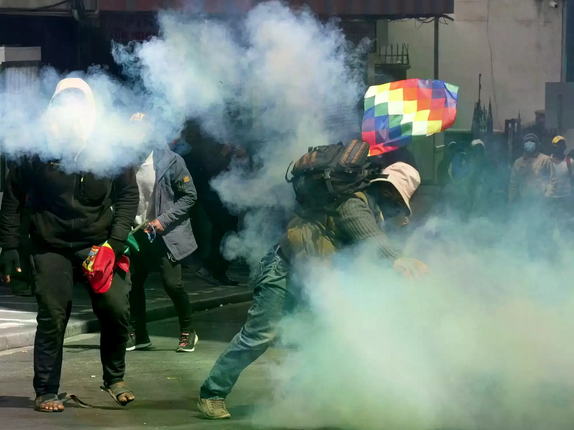 Manifestantes devuelven latas de gas lacrimógeno disparadas por policías durante un enfrentamiento en La Paz.