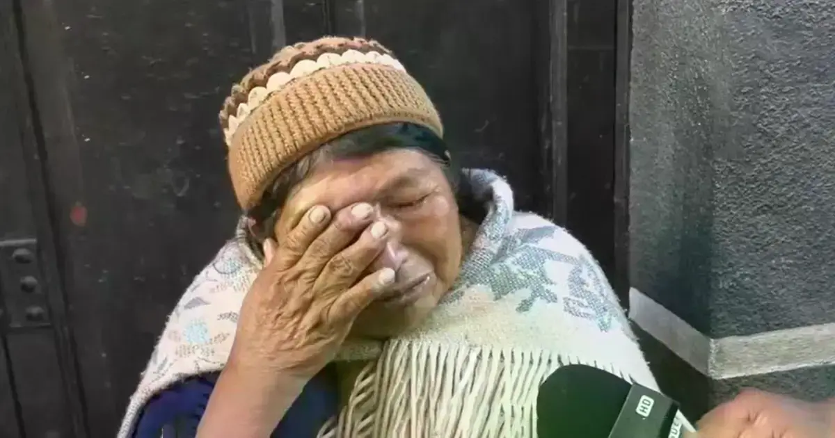 Comerciante afectada llora frente a su puesto quemado en La Paz