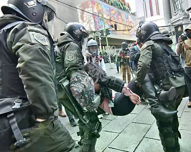 Una periodista es rescatada por la Policía tras ser afectada por gases lacrimógenos.