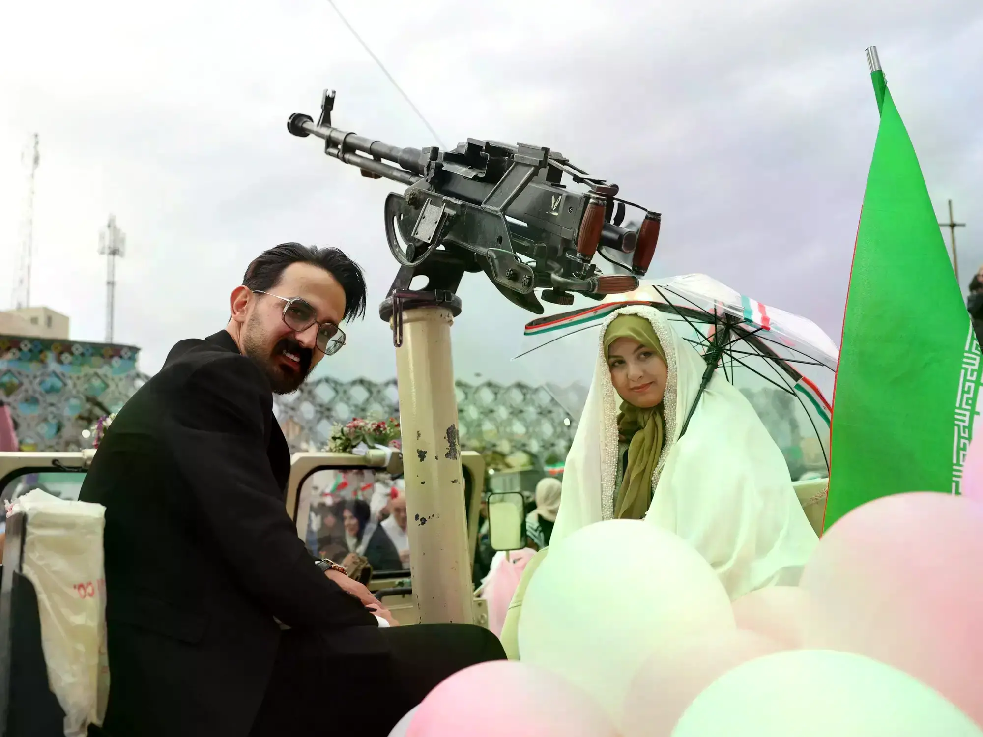 Una pareja de novios iraníes llega en un vehículo militar durante una boda colectiva en Teherán.