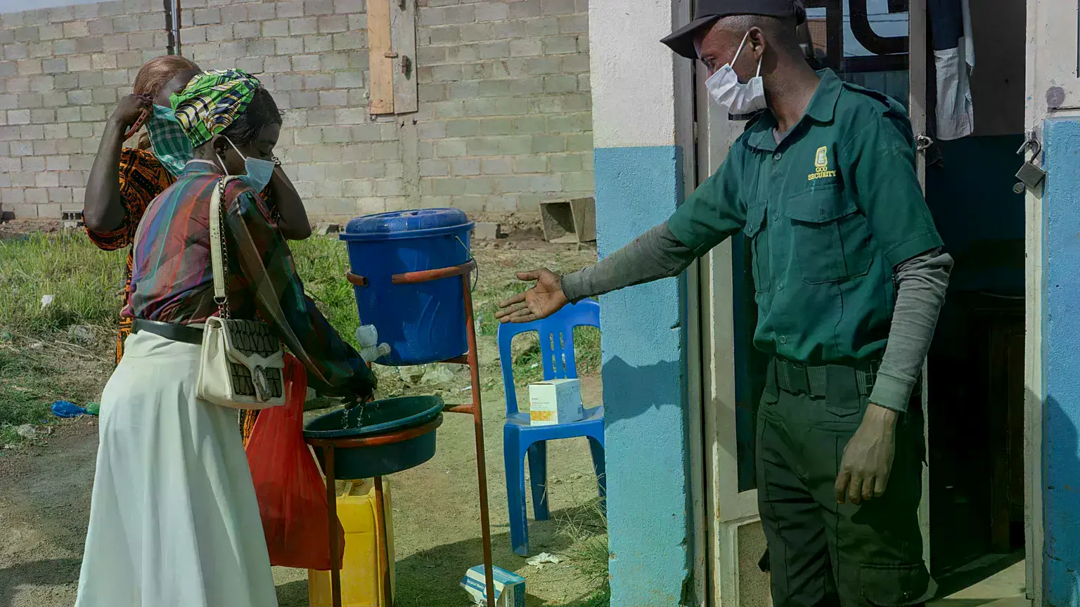Varias personas se lavan las manos a la entrada de un hospital en Bunia, Congo.