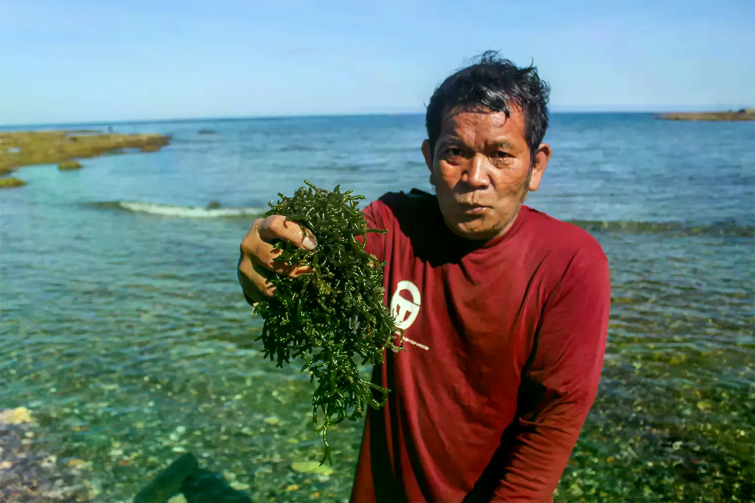 Un pescador en Burgos, Ilocos Norte, extiende gamet para secar en la playa.