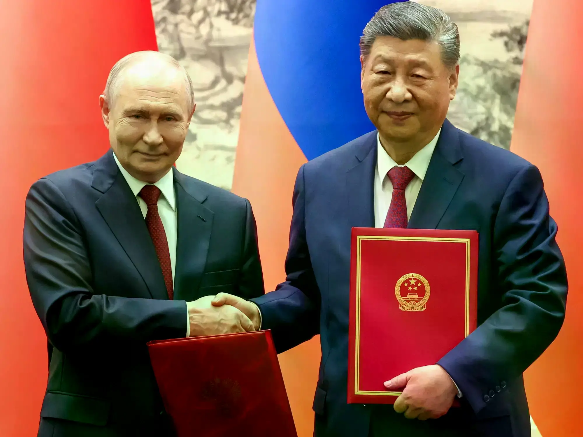 Vladimir Putin y Xi Jinping se dan la mano en el Gran Salón del Pueblo.