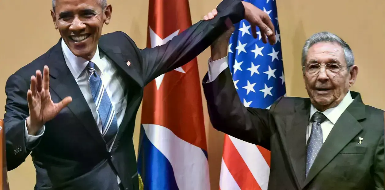 El presidente cubano Raúl Castro levanta la mano del presidente estadounidense Barack Obama durante una reunión en el Palacio