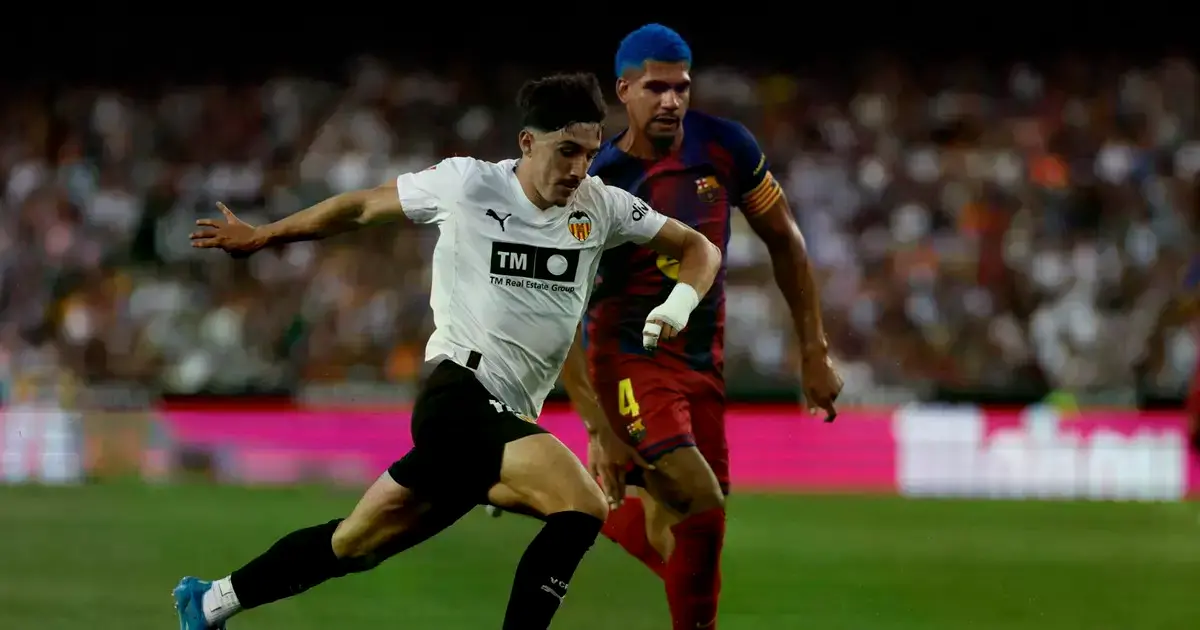El delantero del Valencia Diego López pelea un balón con Ronald Araújo.