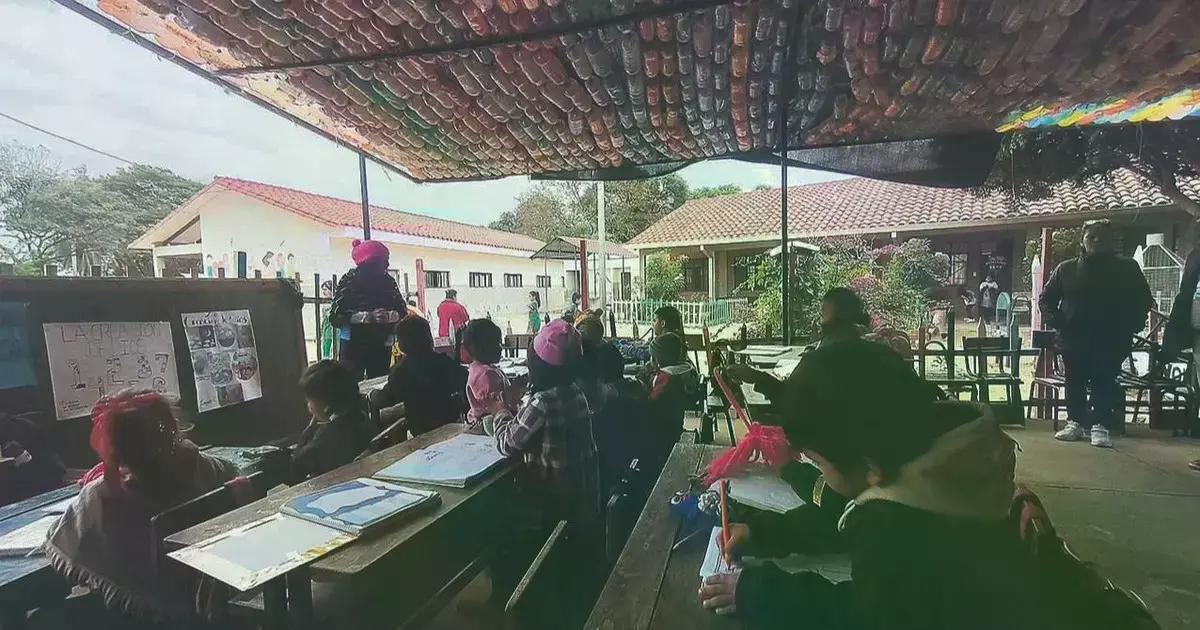 Esta maestra enseña bajo un techo improvisado y con la pizarra en el piso, en el prekínder de la escuela Tundy