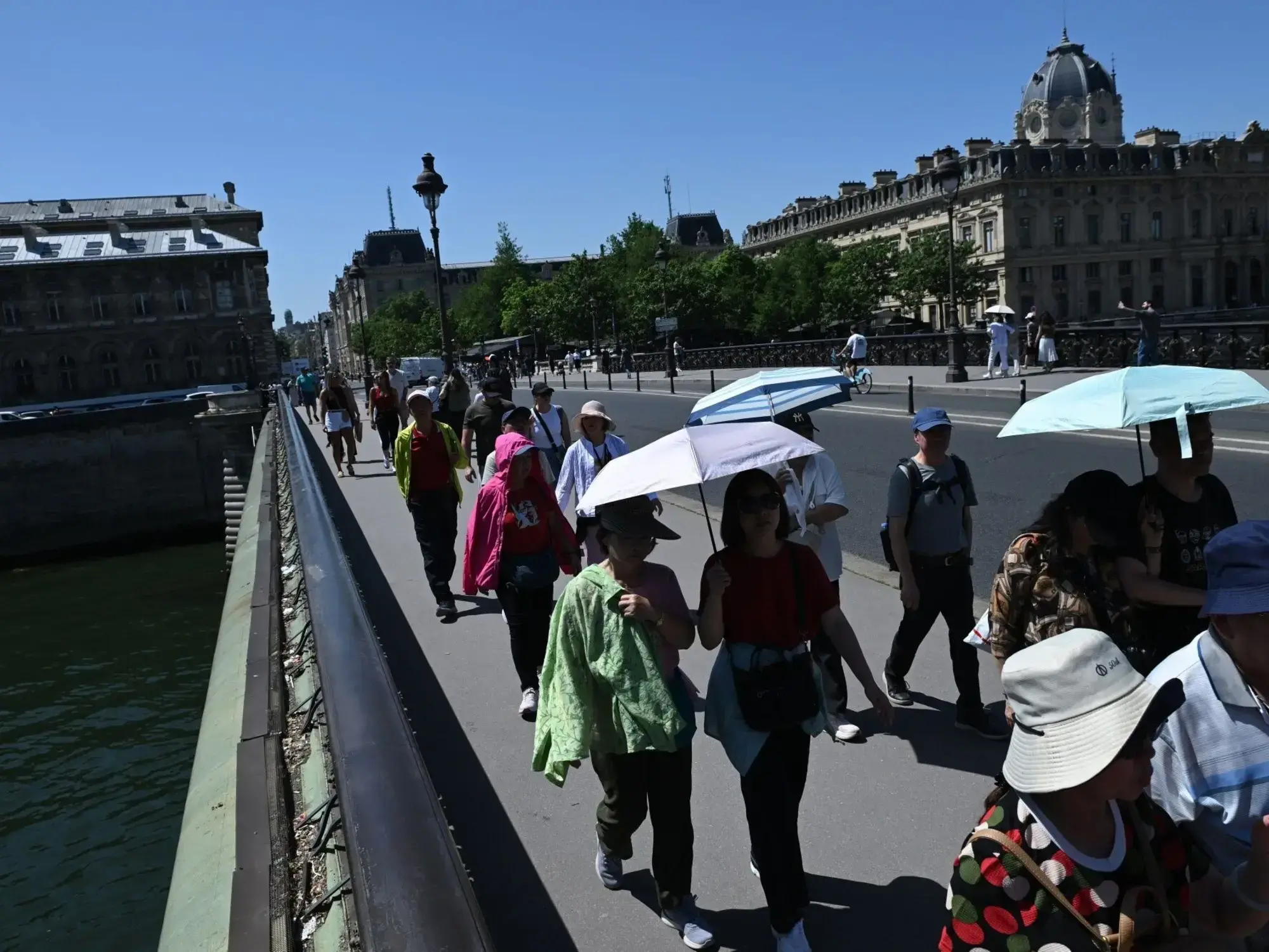 Turistas con sombrillas en París durante la ola de calor.