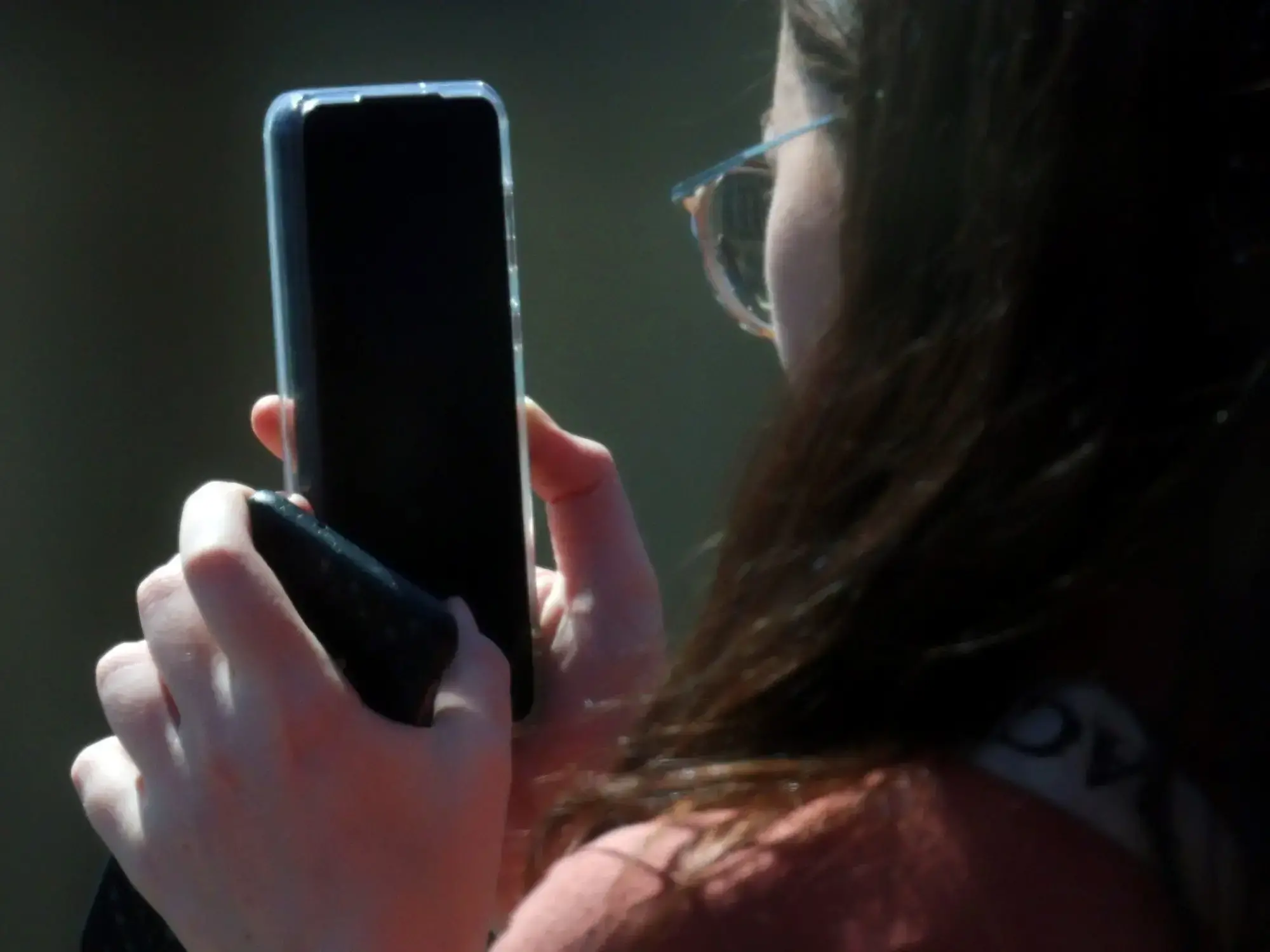 Una joven mira su celular, en Londres
