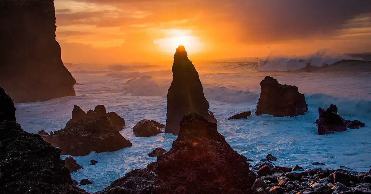 Formaciones rocosas emergen de las olas a lo largo de la costa de Islandia.