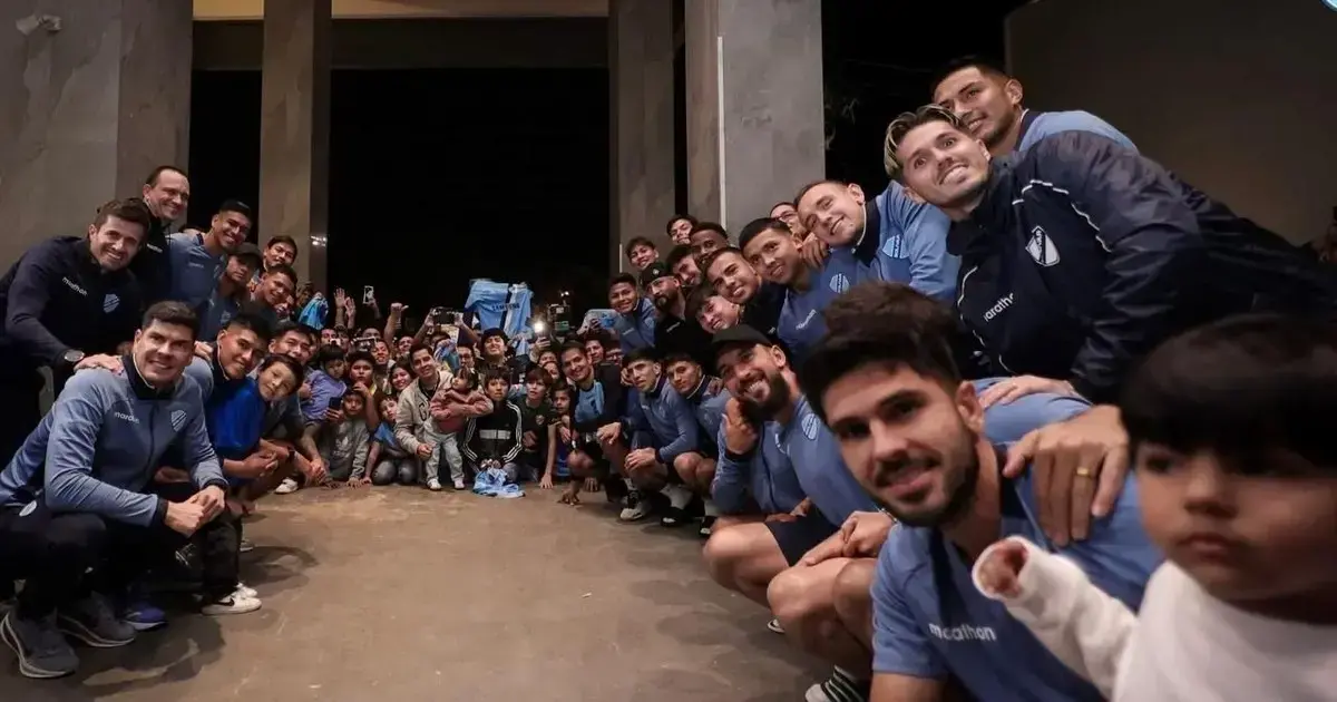 Jugadores de la Academia posan con hinchas protagonistas de un banderazo de apoyo en Santa Cruz.