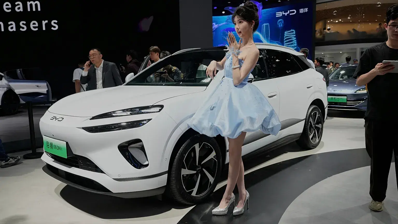 Una modelo posa junto al Sea Lion 06 DM-i de BYD en el salón del automóvil de Shanghái, el miércoles 23 de abril de 2025.