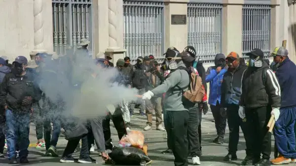 Un grupo de manifestantes hacen detonar petardos contra los uniformados.