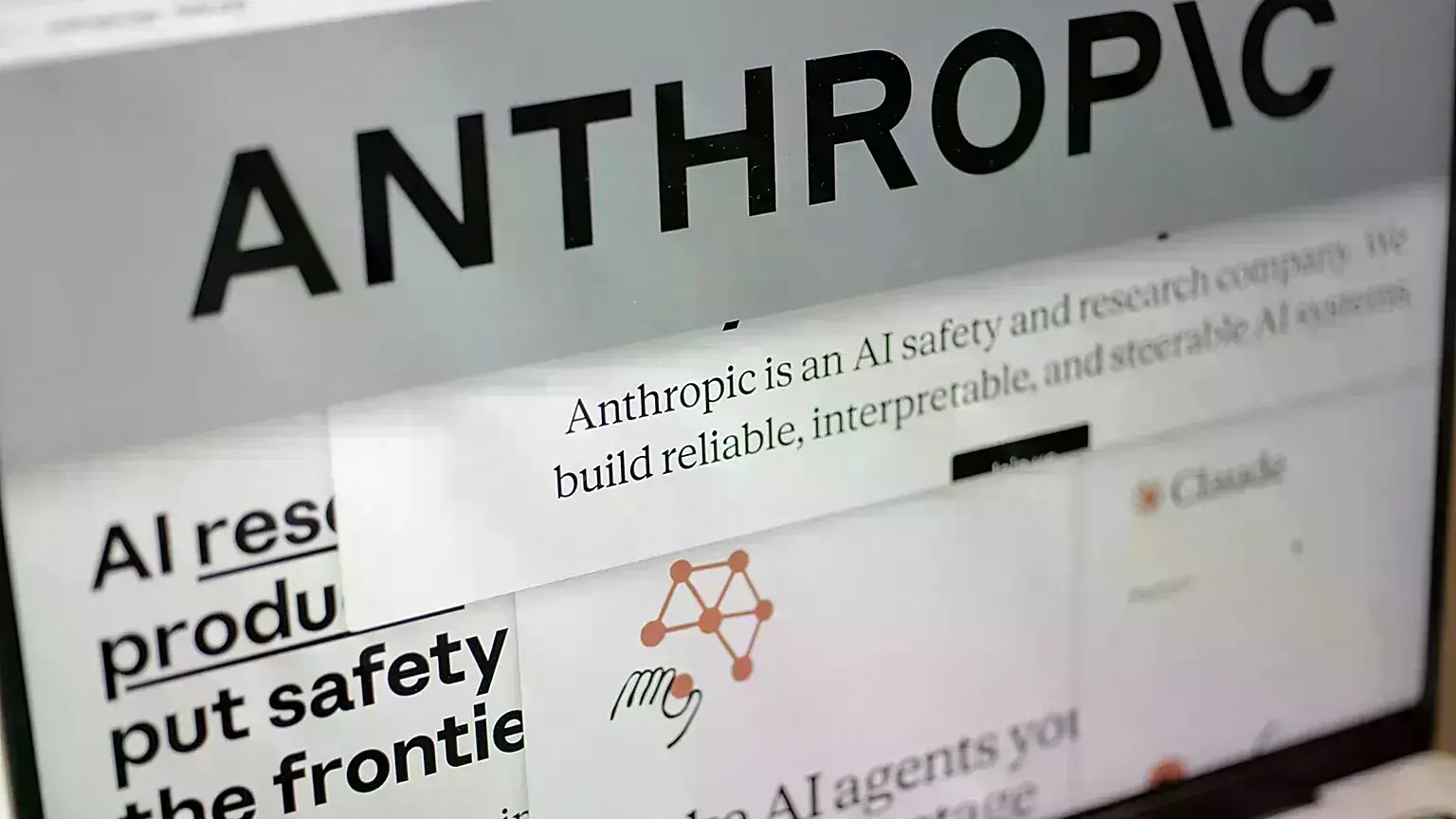 Páginas del sitio web de Anthropic y el logotipo de la empresa en una pantalla en Nueva York.
