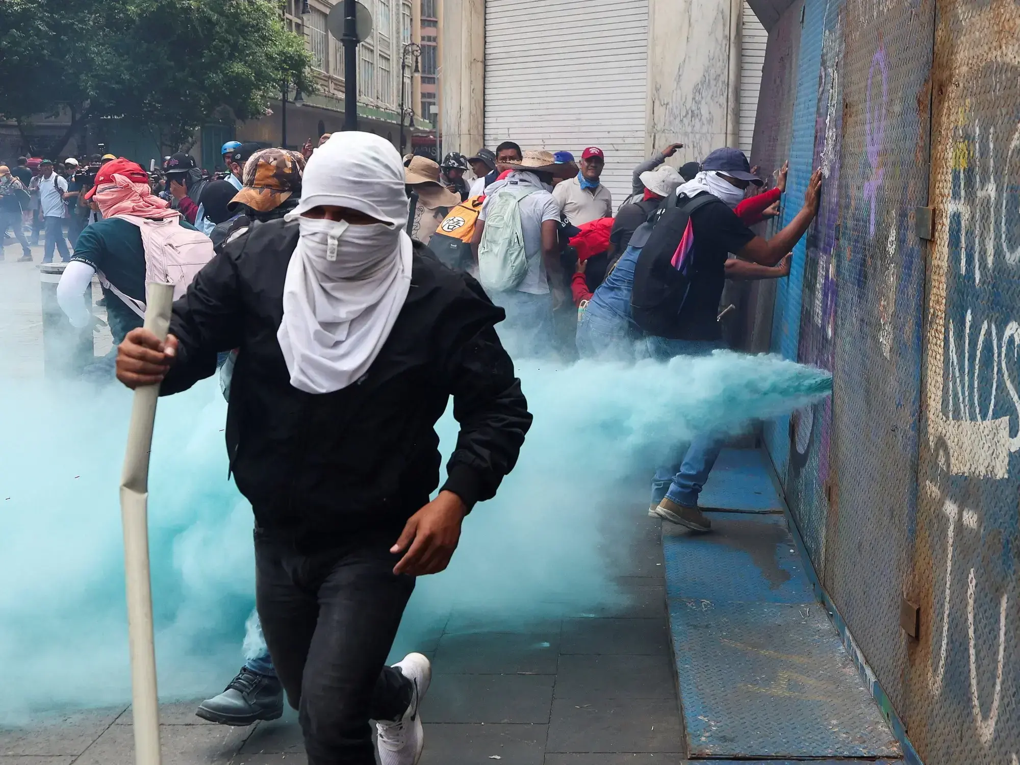 Manifestantes de la CNTE intentan derribar una valla durante una protesta en Ciudad de México.