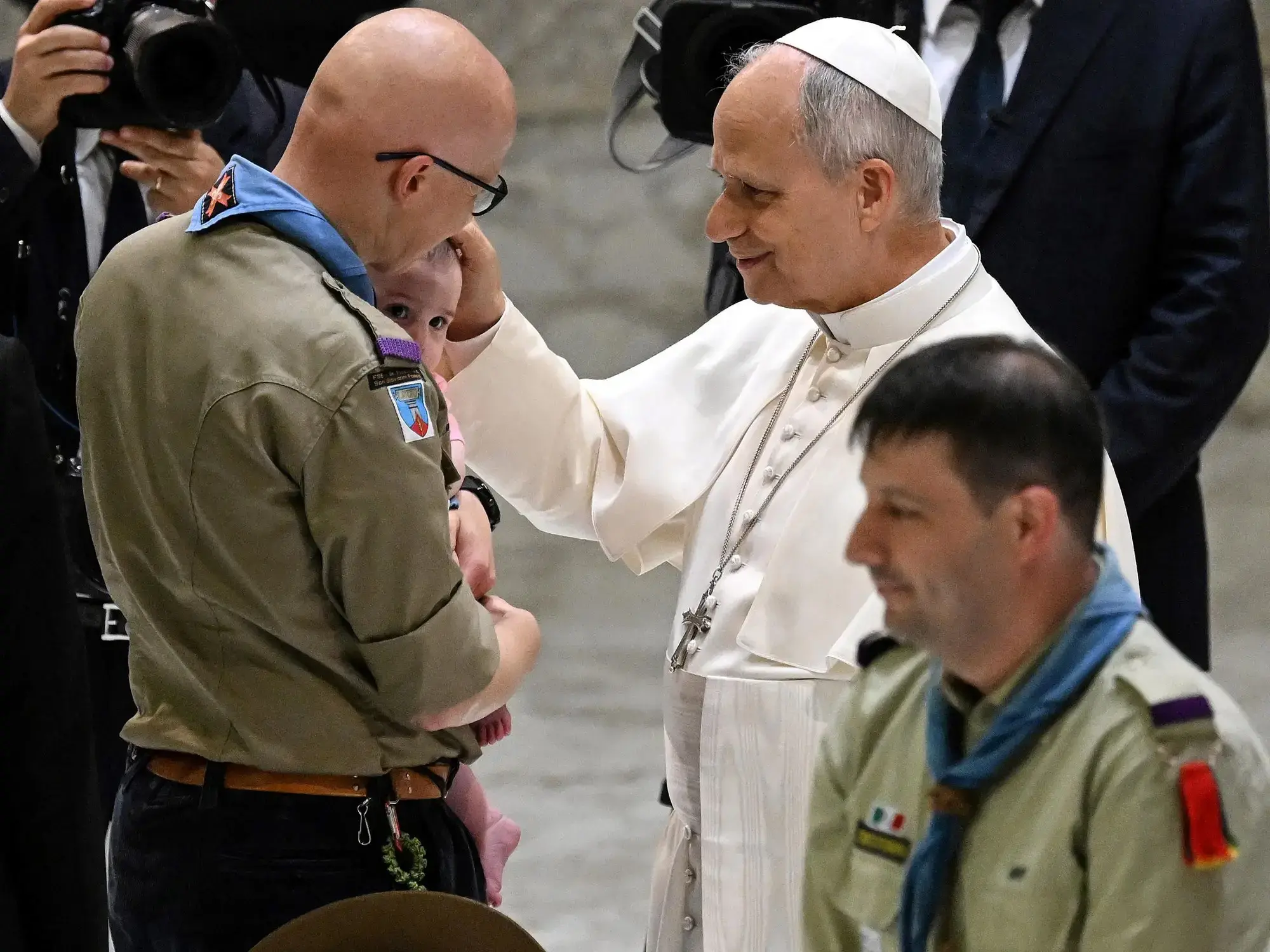 El Papa bendice a un niño durante una audiencia con scouts en el Vaticano.