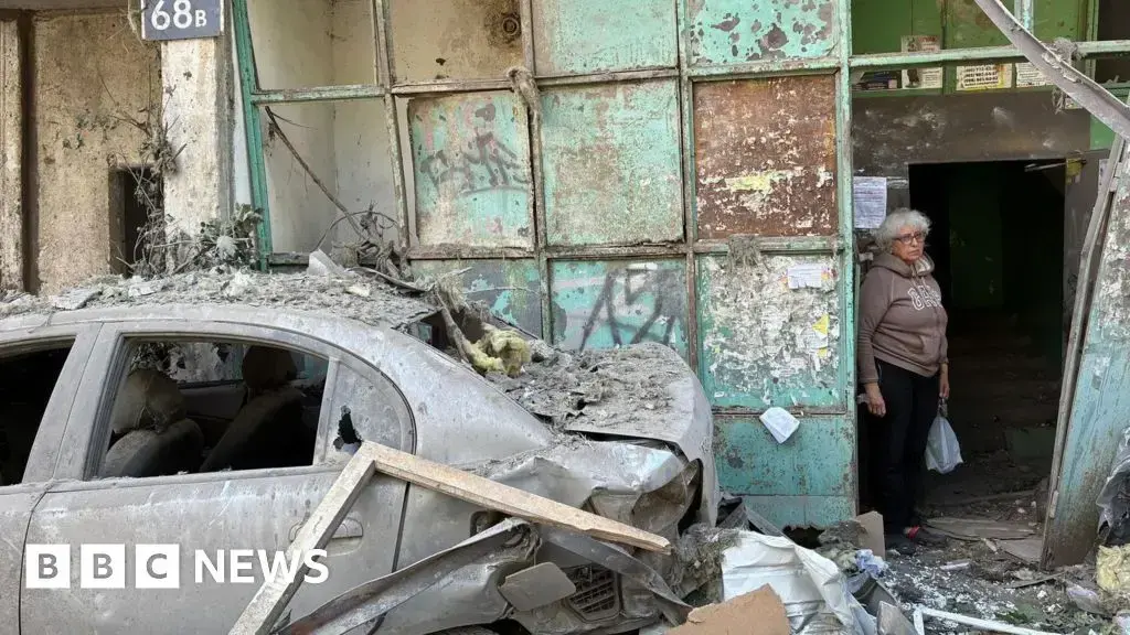 Vecinos observan los restos de un ataque ruso en el barrio de Vynohradar, en Kiev.