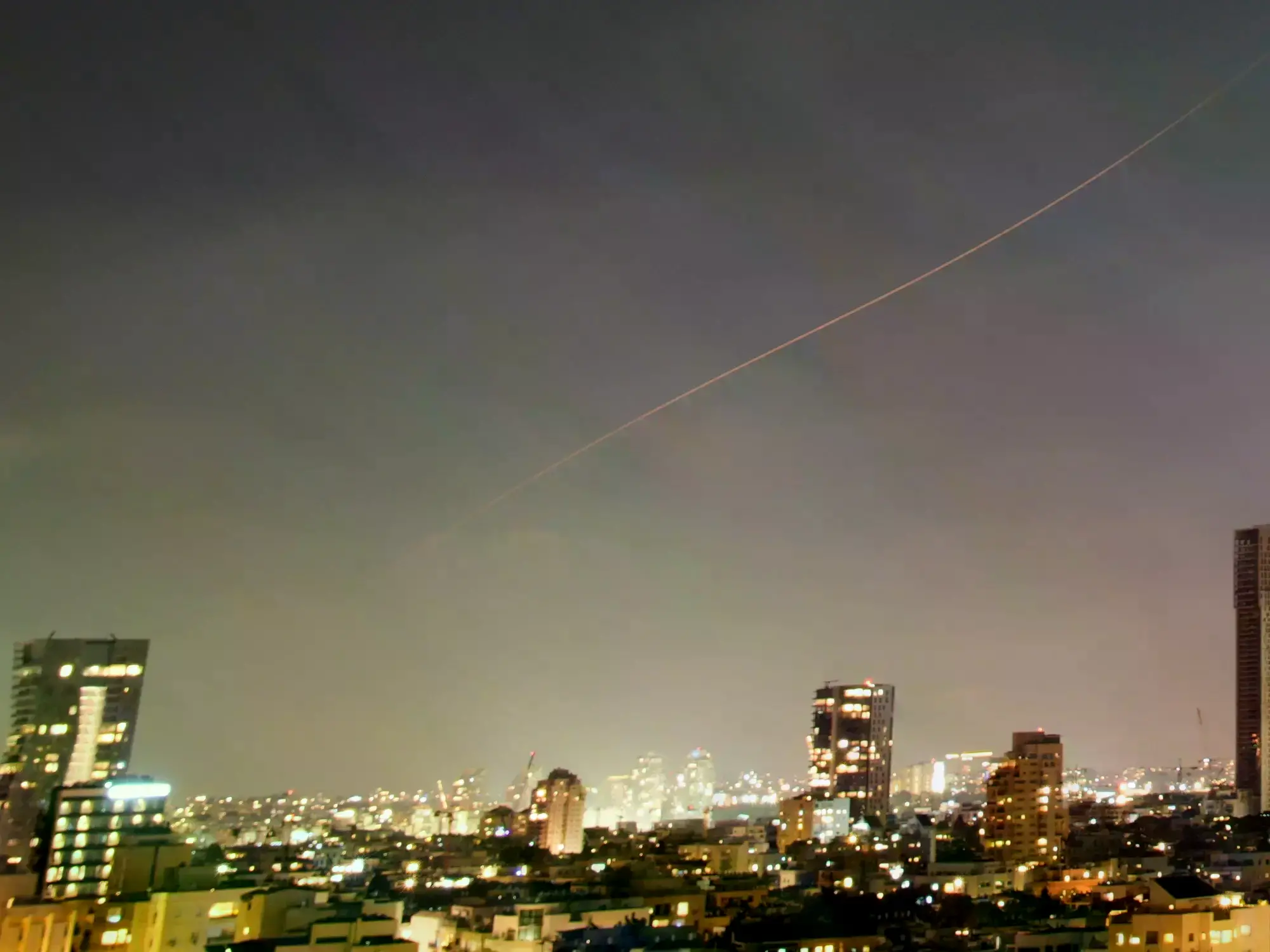 Un misil iraní surca el cielo sobre el centro de Israel durante un ataque con misiles, este domingo.
