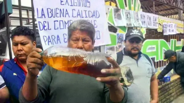 Transportistas muestran la gasolina contaminada que dañó sus motorizados.
