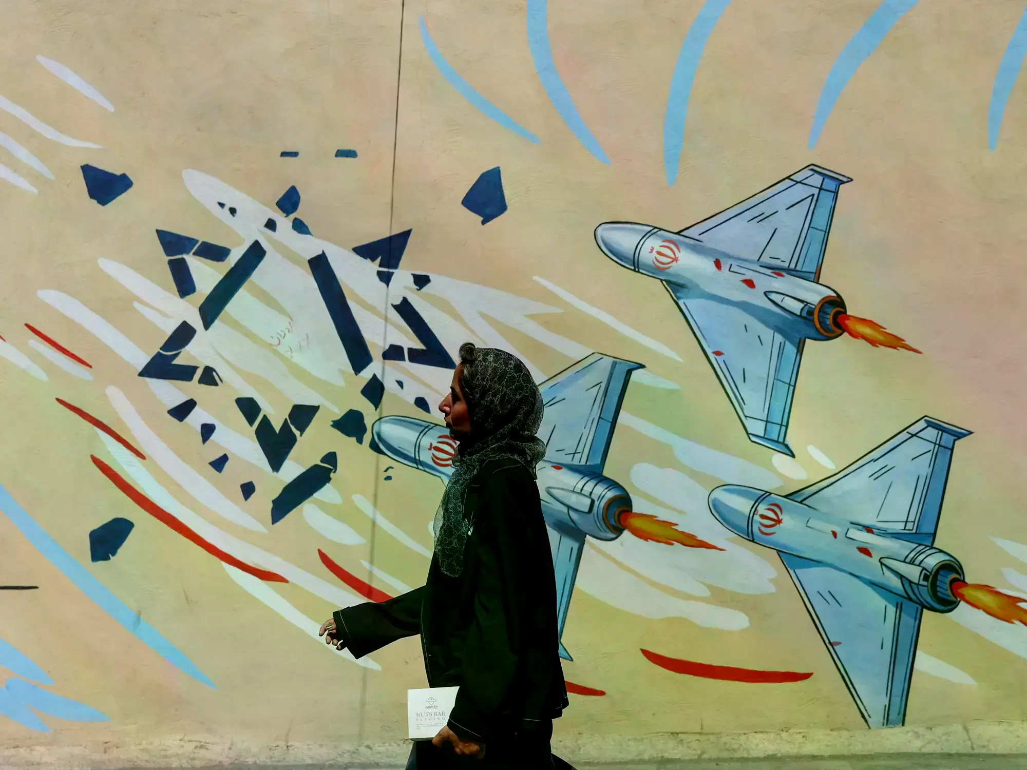 Una mujer iraní pasa junto a un mural antiisraelí en Teherán.