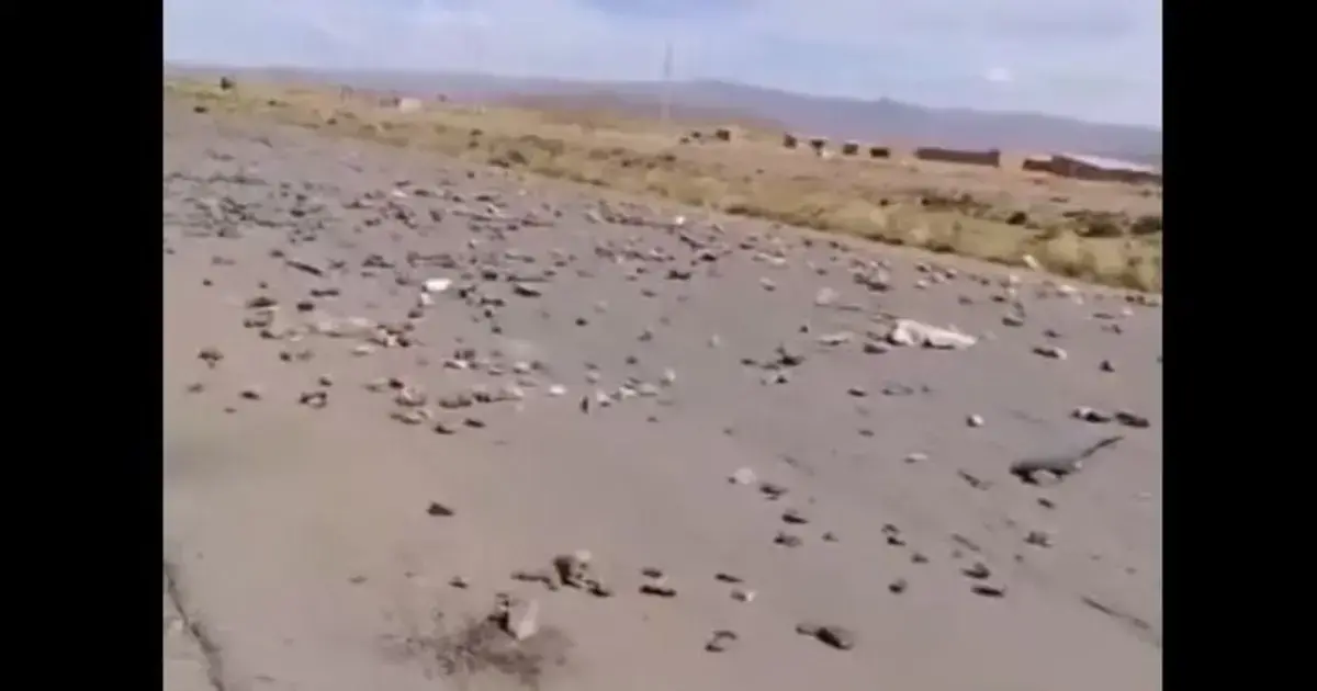 Campesinos en Konani; la carretera luce desierta con solo piedras sobre la vía.
