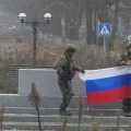 Soldados rusos sostienen una bandera de su país en Pokrovsk, en la región ucraniana de Donetsk