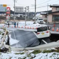 Un auto atrapado en un enorme cráter provocado por el terremoto en Japón.