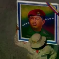 Un miembro de la Milicia Bolivariana sostiene un cartel de Hugo Chávez en una concentración en Caracas.