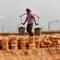 Humo sale de una chimenea mientras trabajadores laboran en un campo de ladrillos en las afueras de Dhaka, 2012.