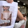 Un manifestante sostiene la foto de una muñeca sexual con apariencia infantil frente a la tienda de Shein en París.