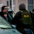 Una mujer discute con un policía durante una redada de inmigración en Minnesota.
